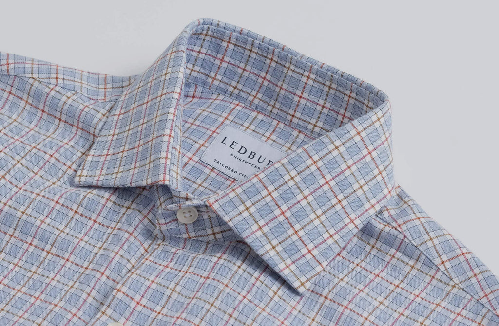 Closeup of the collar of a men's blue, red, and brown check dress shirt by Ledbury 