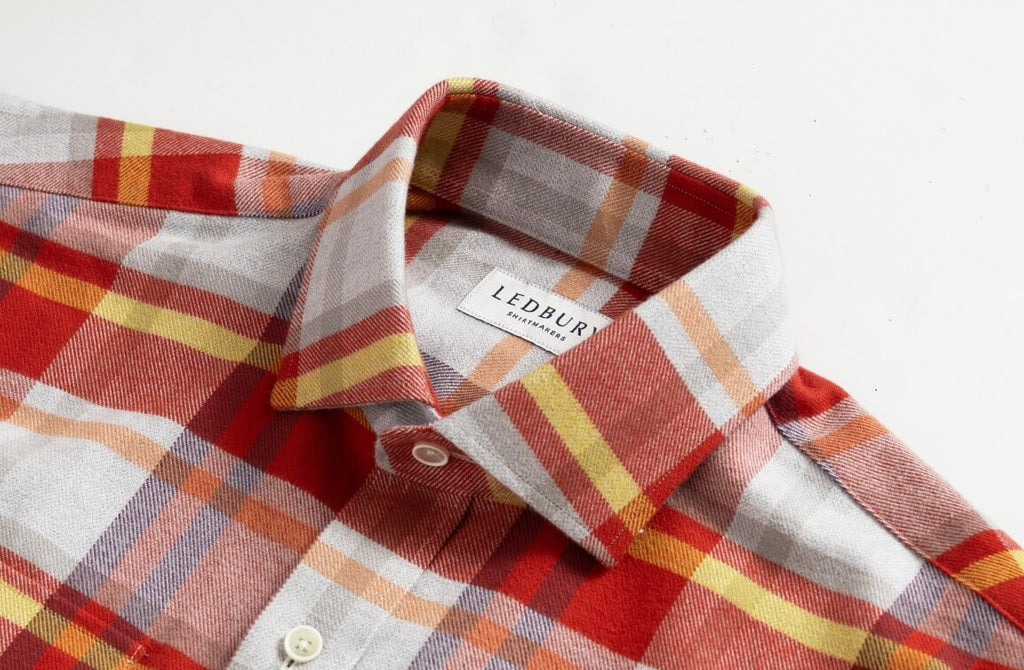 Closeup of the collar of a men's red, orange, grey, and yellow flannel shirt by Ledbury