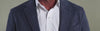 Closeup of a model wearing a men's Ledbury white button down shirt and navy sportcoat, showing the features of Ledbury's signature structured collar